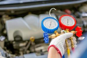 Air Conditioning Repair, repairman holding monitor tool to check and fixed car air conditioner system, Technician check car air conditioning system refrigerant recharge photo