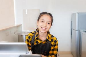 Smiling little girl cashier operating at the cash desk in cafe, education concept photo
