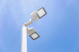 LED street lamp post glowing blue sky with white cloud background. Modern led lights in city photo