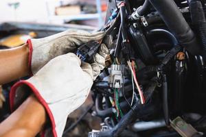 Close up hands of auto mechanic doing car service and maintenance. Car wiring with adapters and connectors changing. photo