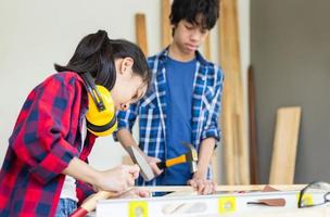 Teenager boy with his little sister building a workshop together in a carpentry workshop. Children team in the craftsman workshop photo