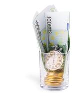 bitcoins en un montón de cien euros y un reloj de bombilla en un vaso vacío foto