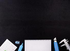 School supplies on black board background. Back to school concept. photo