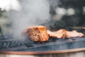 asar a la parrilla en el fuego ahumado en el patio trasero el día foto