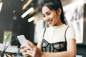 joven empresaria asiática adulta que usa un teléfono móvil para una aplicación de citas en línea en la oficina