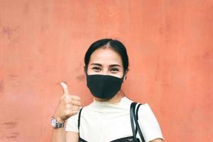 retrato de una joven mujer de negocios asiática adulta que usa mascarilla para el virus protector corona o covid 19 foto