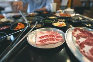 Korea bbq style restaurant  with meat and vegetable side diesh. photo