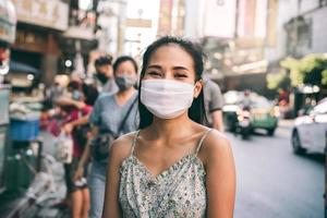 retrato feliz mujer adulta asiática usar máscara en la cara proteger virus corona o covid 19 foto