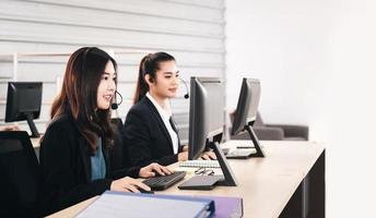 Young business staff asian woman working with headphone and computer for support. photo