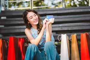 Shopping on sale season holiday concept. Young asian smile woman sit and hold a credit card. photo