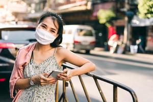 retrato feliz mujer adulta asiática usar máscara en la cara proteger virus corona o covid 19 foto