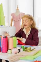 Professional female designers are sewing with small sewing machines on the table. photo