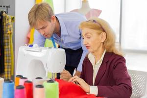 Professional team work designers, young men and elderly women in the office with a variety of fabric tones and equipment for various designs. photo