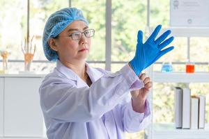 Asian female scientists wearing blue rubber gloves photo