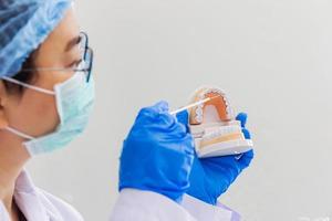 la dentista asiática está introduciendo conocimientos con equipos de dentaduras postizas en clínicas dentales.