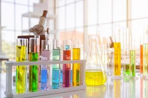botellas de reactivos químicos, botellas de experimentos científicos de varias formas, tamaños y microscopios sobre la mesa foto
