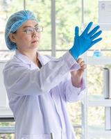 Asian female scientists wearing blue rubber gloves