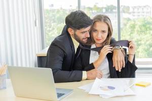 Two young businessmen, men and women, work at the office with a tablet and accompanying documents on the desk with smiles and happiness. photo