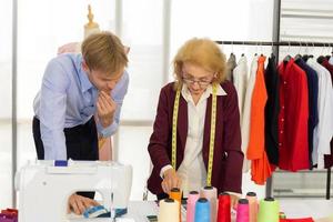 Professional team work designers, young men and elderly women in the office with a variety of fabric tones and equipment for various designs. photo