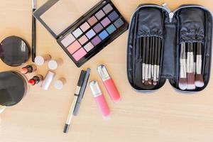 Many make-up cosmetics on the wooden table photo