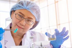 An Asian female scientist is researching a chemical formula in a lab. photo