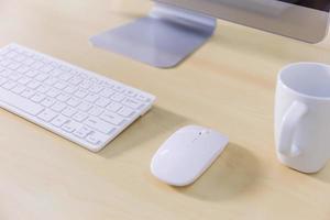 Office desk table with computer and coffee cup. Top view photo