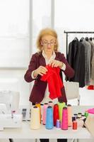 Professional female sewing designers in the office have a variety of fabric color schemes. photo