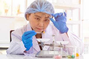 An Asian female scientist is researching a chemical formula in a lab. photo