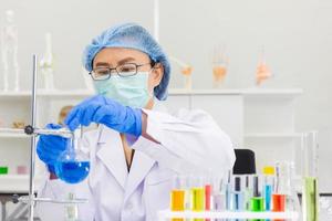 An Asian female scientist is researching a chemical formula in a lab. photo