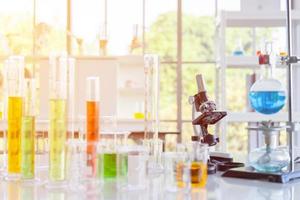 Chemical reagent bottles, scientific experiment bottles of various shapes, sizes and microscopes on the table photo