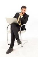Handsome businessman sitting on a tablet on a metal chair isolated on white background, photo