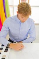 Male designers who are sketching on paper to design clothes photo