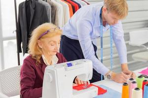 Professional team work designers, young men and elderly women in the office with a variety of fabric tones and equipment for various designs. photo