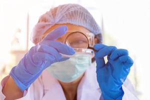 An Asian female scientist is researching a chemical formula in a lab. photo