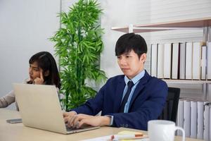 Two male businessmen and business women sit and work in the office. photo