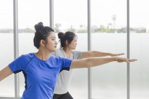 dos mujeres asiáticas de mediana edad haciendo yoga en el gimnasio. foto