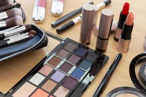 Many make-up cosmetics on the wooden table photo