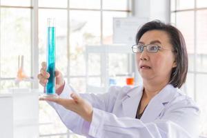 An Asian female scientist looked at the glass tube in shock. photo