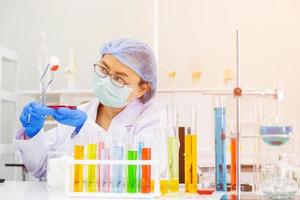 An Asian female scientist is researching a chemical formula in a lab. photo