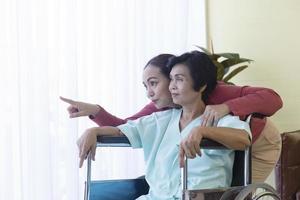 la familia asiática, que es una madre enferma, está en silla de ruedas, está hospitalizada y tiene una hija que cuidar. foto