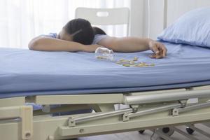 pacientes femeninas en el hospital sobredosis inconscientes al lado de la cama. foto