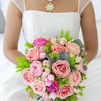 A beautiful bouquet of flowers in the bride's hand that is about to enter the wedding ceremony photo