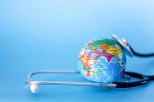 Stethoscope and planet earth on a blue background. Green Earth Day, photo