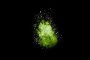 Abstract green dust explosion on black background. Green powder splattered. photo