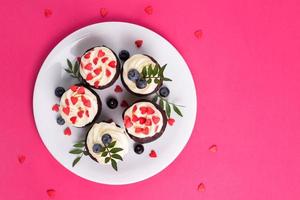 pastelitos de terciopelo rojo para el día de san valentín en un ambiente rosa brillante foto