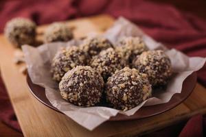 Cocoa balls, chocolate truffles cakes on board on wooden background photo