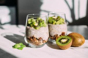 Healthy breakfast. chia pudding with kiwi and granola in glass photo