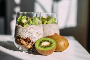 desayuno saludable. budín de chía con kiwi y granola en vaso foto