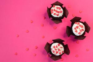 Red velvet cupcakes for Valentines Day in bright pink setting photo