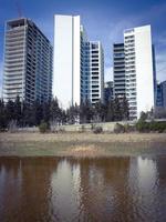 Modern multistory buildings reflected in water. Puddle with reflections. photo